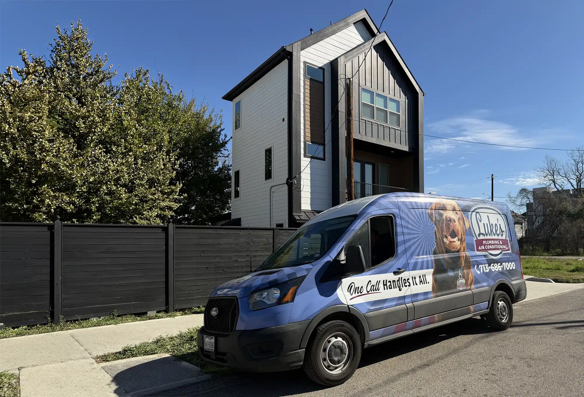 Luke's Plumbing & Air Conditioning service van with the company's Labrador wrap pulling up to a Houston home